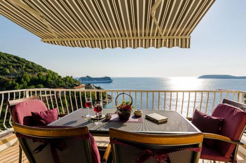 een tafel op een balkon met uitzicht op de oceaan bij Indy's Beach Apartments in Dubrovnik
