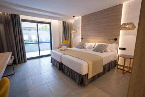 a bedroom with a large bed and a large window at Hotel Morlans Suites - Adults Only in Paguera