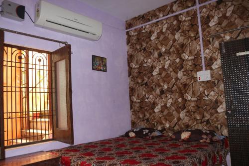 a bedroom with a bed and a stone wall at Mother Hostel in Varanasi