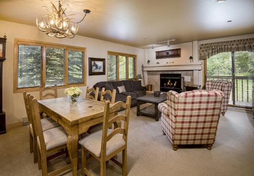 a living room with a table and chairs and a fireplace at Townsend Place B-106 condo in Beaver Creek