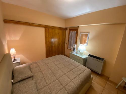 um quarto com uma cama e duas mesas e um candeeiro em Livata - Campo dell’Osso...nel bosco a 1.700 metri em Livata