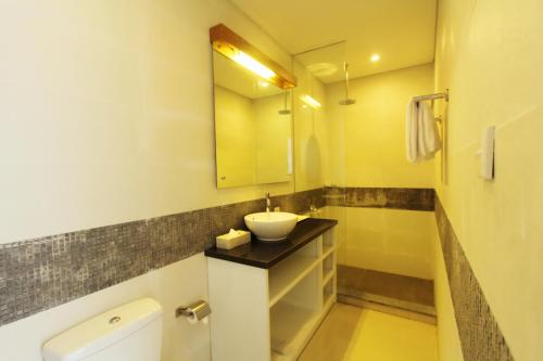 a bathroom with a sink and a mirror at Apple Suite in Kerobokan