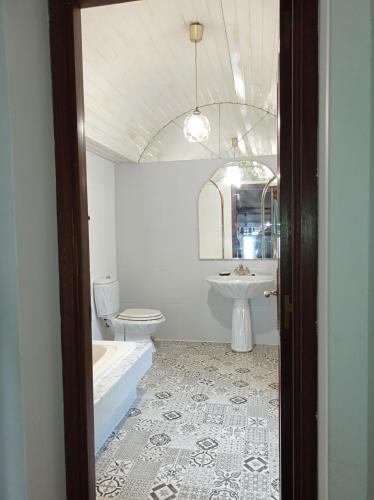 a bathroom with a tub and a toilet and a sink at A Mercé in A Pobra do Caramiñal