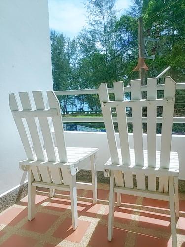 two white chairs sitting on a porch at Aromdee at Naithon Beach in Nai Thon Beach