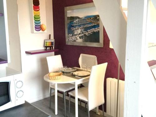 une salle à manger avec une table et des chaises blanches dans l'établissement Très joli duplex Port Crouesty Morbihan, à Arzon