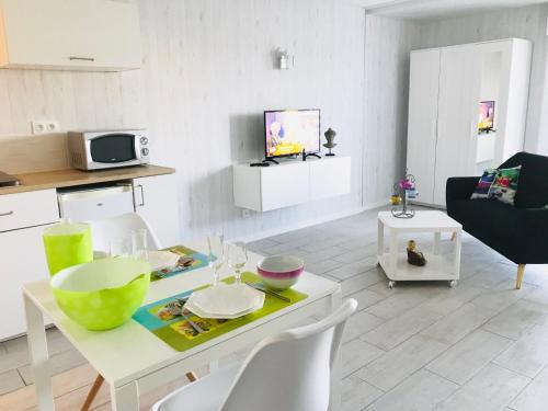 eine Küche und ein Wohnzimmer mit einem Tisch und Stühlen in der Unterkunft Studio Les Remparts de Kerjouanno in Arzon