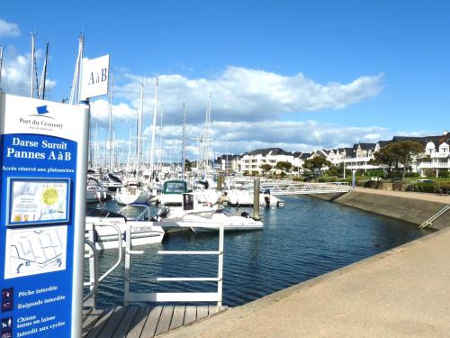 un port de plaisance avec des bateaux dans l'eau et un panneau dans l'établissement Studio Les Hameaux du Crouesty, à Arzon