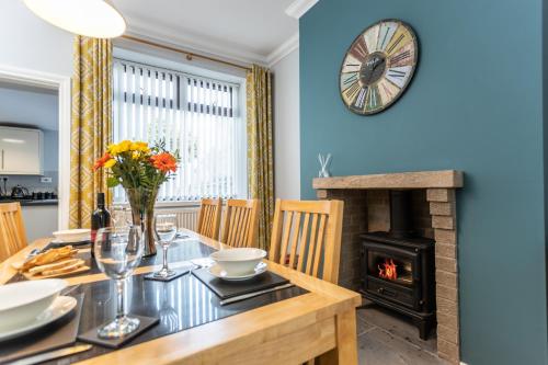 a dining room with a table and a wood stove at Merlin House in Cockfield