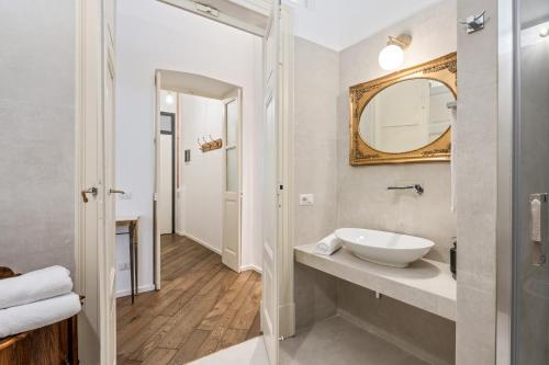 un baño con lavabo y espejo en Palazzo della Pilotta Roomy and Quiet Flat, en Parma