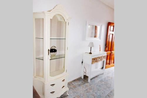 einen weißen Schrank und einen Schreibtisch in einem Zimmer in der Unterkunft Apartamento muy cerca del mar. in Arenales del Sol