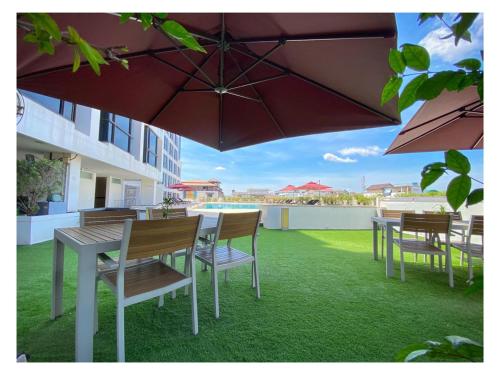 a patio with tables and chairs and an umbrella at Lao Plaza Hotel in Vientiane