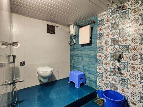 a bathroom with a toilet and a blue stool at Morocco Green Villa in Nagaon