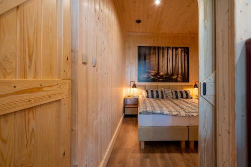 um quarto com uma cama num quarto de madeira em Apartamenty Leśna Przystań em Węgorzewo