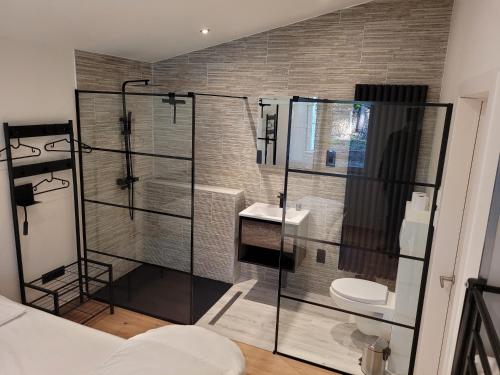 een badkamer met een glazen douche en een toilet bij Hogenberg Heiken Lichtaart / Kasterlee in Lichtaart