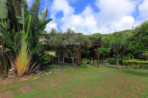 a house in the middle of a yard at 近月旭海莊園民宿 in Yanliau