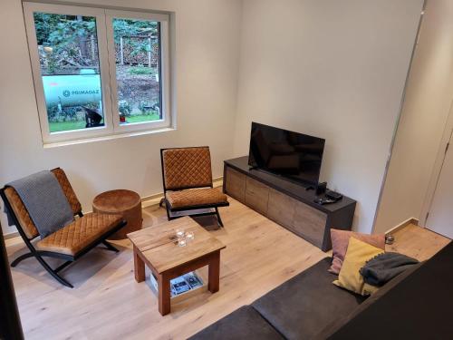 ein Wohnzimmer mit Couch und Fernseher in der Unterkunft Hogenberg Heiken Lichtaart Kasterlee met eigen laadpaal in Lichtaart