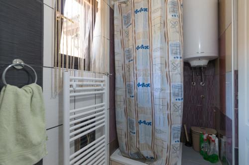 uma casa de banho com uma cortina de chuveiro e uma toalha em Bogu iza nogu 2 em Bajina Bašta