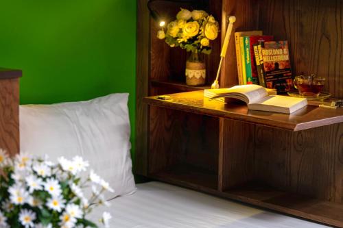 a bedroom with a green wall and a table with a book at Little Charm Hanoi Hostel - Homestay in Hanoi