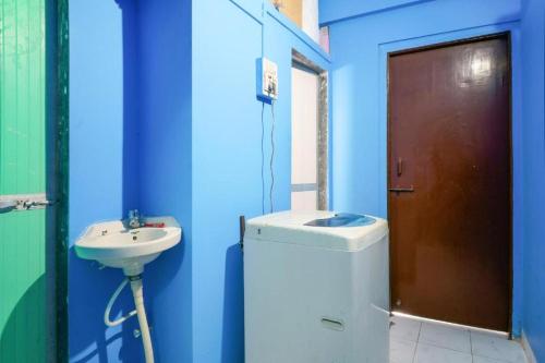 a blue bathroom with a sink and a toilet at Satya Vacation Stay in Alibaug