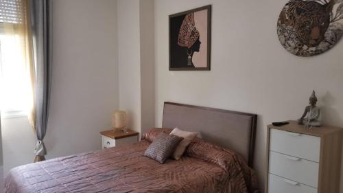 a bedroom with a bed and a clock on the wall at Duplex de lujo en la playa , jacuzzy, piscina, chimenea y padel in Benalmádena