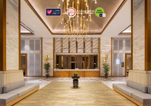 a lobby with a chandelier in a building at Swiss-Belhotel Solo in Solo