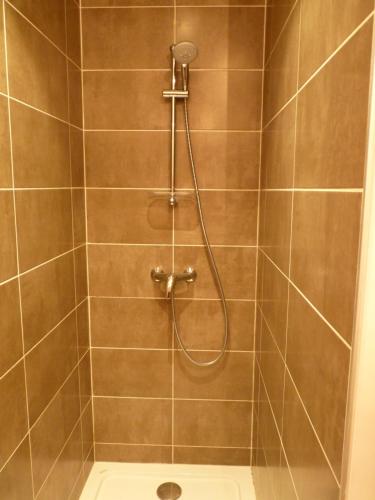 La salle de bains est pourvue d'une douche avec un tuyau. dans l'établissement Aux Pierres de Nozières, à Gramat