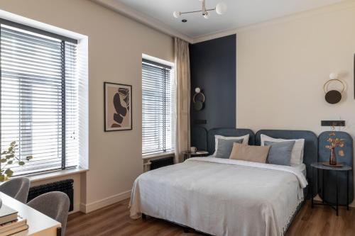 a bedroom with a bed and two windows at Hotel Point by Academia in Saint Petersburg