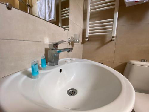 a white sink in a bathroom with a toilet at Ponte in Kutaisi