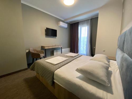 a hotel room with a bed with two pillows at Ponte in Kutaisi