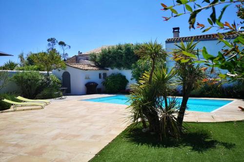 une maison avec une piscine dans une cour dans l'établissement ILE DE RÉ - Villa Sylvabelle, à La Flotte