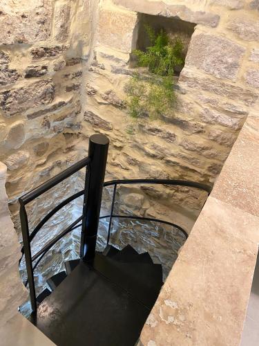 a stone wall with a metal railing and water at La Maison des Vendangeurs - TABLE D'HÔTES le soir du jeudi au dimanche- Jacuzzi - Balnéo SPA - ACCES PISCINE pour toutes les chambres sauf STUDIO COQUET- Piscine de mai à mi-octobre in Martignargues