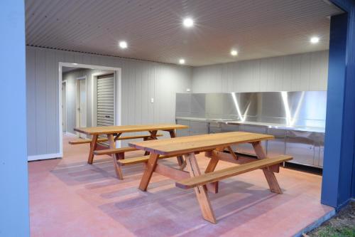 2 Holzbänke in einer Küche mit einem Tisch in der Unterkunft Comfort Inn Serenity Bathurst in Bathurst