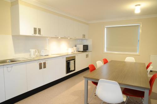 a kitchen with a table, chairs and a microwave at Havannah Accommodation in Bathurst
