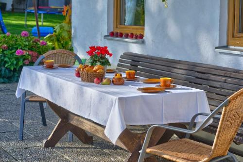 a table with a white table cloth and fruit on it at Brausamhof in Seeon-Seebruck