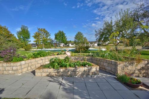 a garden with a stone wall and some plants at Brausamhof in Seeon-Seebruck