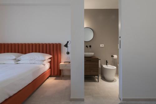 1 dormitorio con cama y baño con espejo. en Heraia, en Ragusa