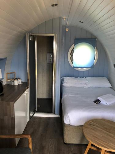 a small room with a bed and a table at Loch Leven Hotel & Distillery in Glencoe