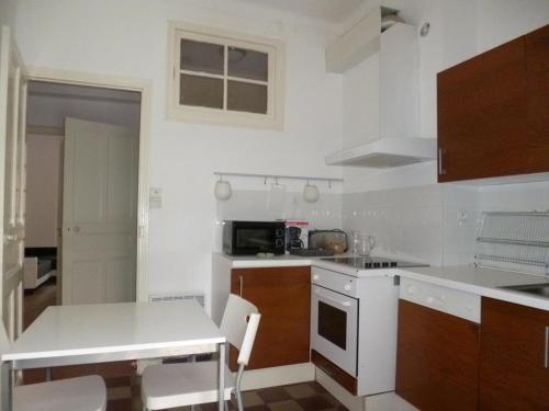een keuken met witte werkbladen en een fornuis met oven bij Kalliste - Appartement centre ville tout équipé in Bastia