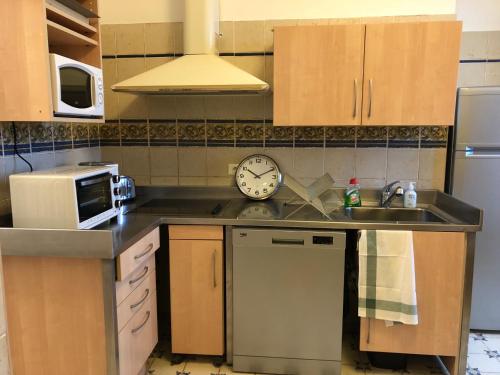 a kitchen with a sink and a clock on the wall at Casella - Appartement centre ville tout équipé in Bastia