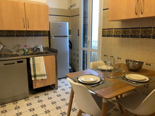 Il comprend une cuisine équipée d'une table, de chaises et d'un réfrigérateur. dans l'établissement Casella - Appartement centre ville tout équipé, à Bastia