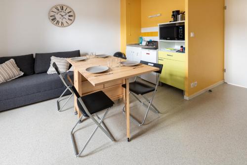 - une cuisine avec une table et des chaises dans le salon dans l'établissement Studio centre ville avec parking privé, à Cholet