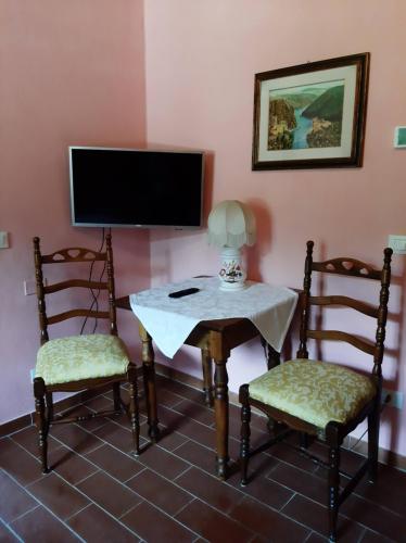 a room with two chairs and a table and a tv at Villa Belvedere in Pieve Fosciana