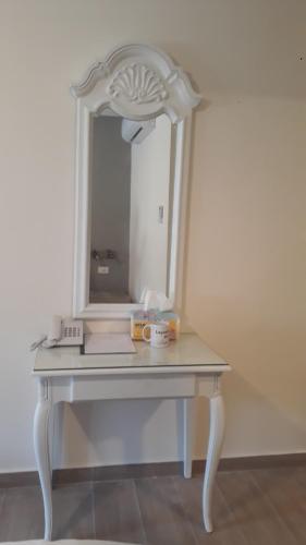 a white dressing table with a mirror on it at Layaali Amman Hotel in Amman