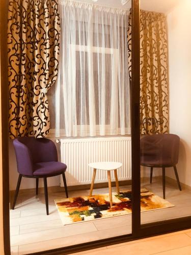 a mirror in a room with two chairs and a window at APARTAMENT PARK in Brăila