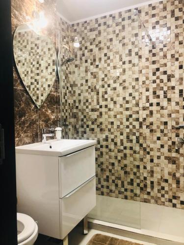 a bathroom with a white sink and a mirror at APARTAMENT PARK in Brăila