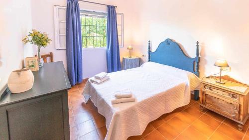 ein Schlafzimmer mit einem großen Bett und einem Fenster in der Unterkunft Casa Rural Santa Ana in Marchena