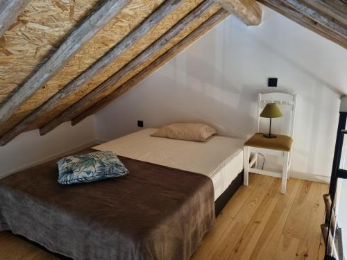 a bedroom with a bed and a table with a lamp at A Casinha in Caldas da Rainha