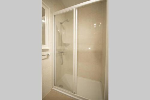 een douche met een glazen deur in de badkamer bij Villa Garbes in Cala Galdana