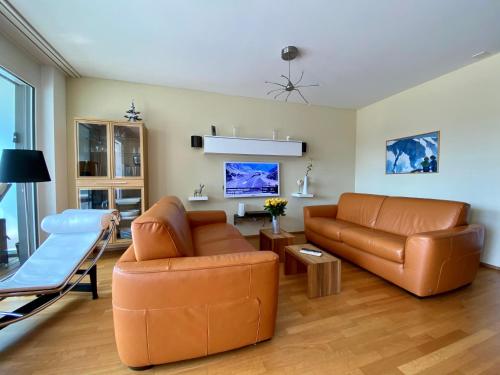 ein Wohnzimmer mit einem Sofa und einem Stuhl in der Unterkunft At Rinaldi 22 in Davos