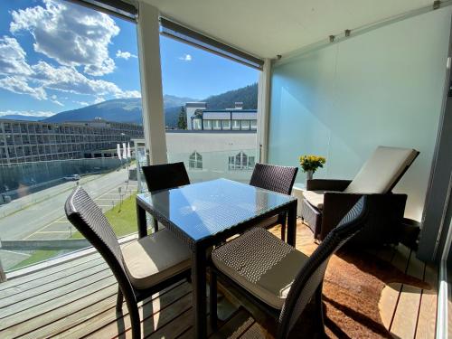 un tavolo e sedie su un balcone con vista di At Rinaldi 22 a Davos